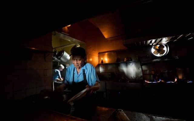 Un cocinero trabaja a oscuras en un restaurante durante una falla eléctrica. EFE/MIGUEL GUTIÉRREZ